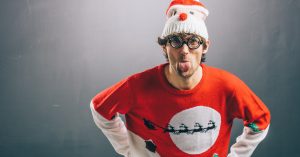 Guy in ugly christmas sweater sticking out tongue
