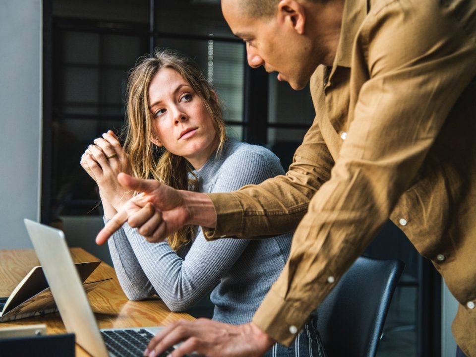 People discussing and giving advice next to computer