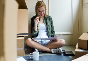 Portrait of young beautiful woman moving in new home.