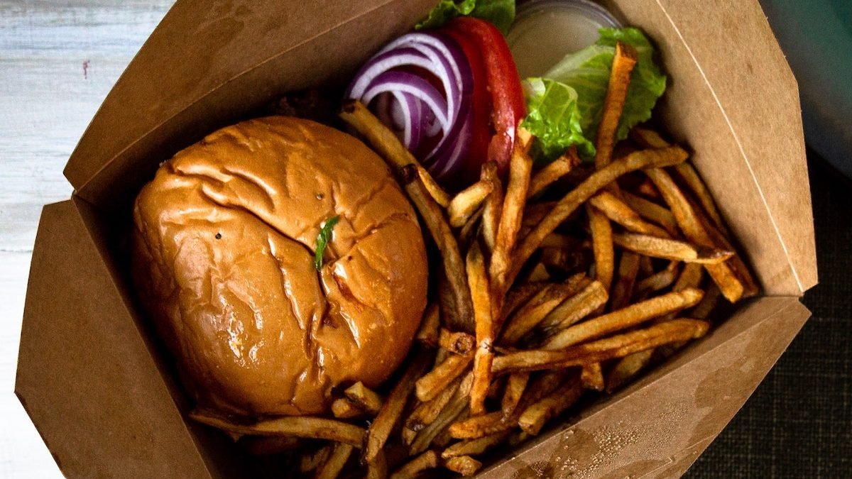 cheeseburger and french fries in a takeout box