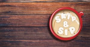wooden background red mug with hot chocolate in it and the words sip & skip in marshmello like words on top