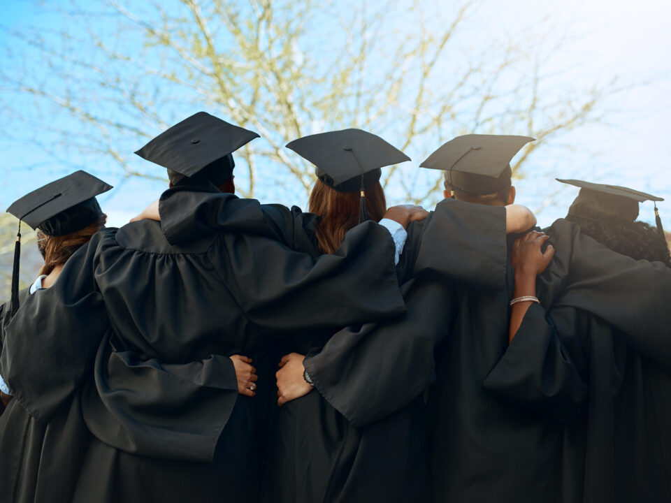 Embrace, group of graduates and together with joy on graduation day or celebrating academic achievement and outdoors. Certification, young students and hug outside or robes or hats and education.