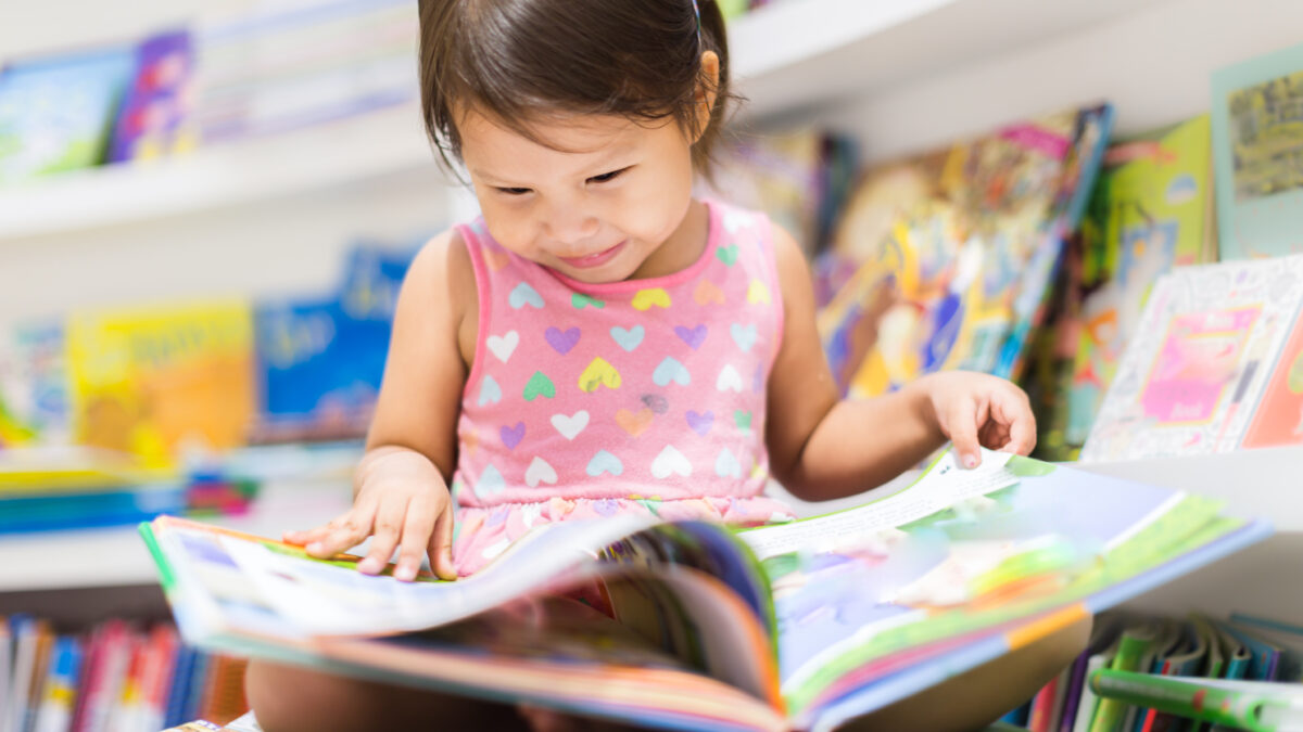 Little girl reading a book. Education.