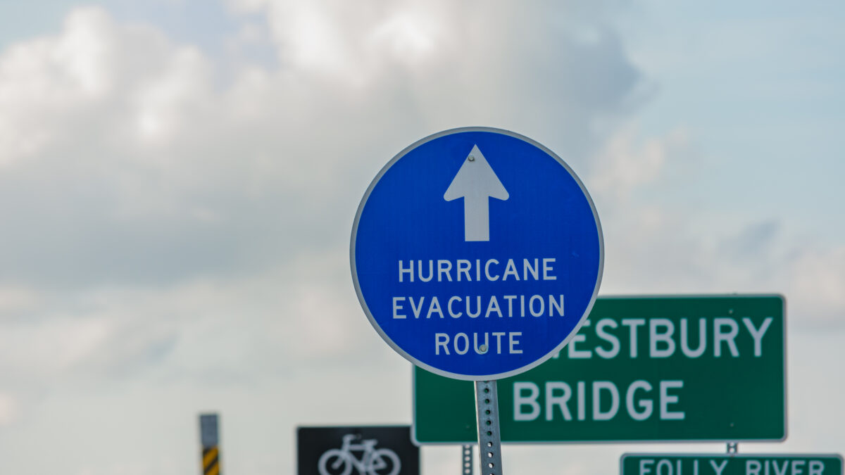 Blue sign with an arrow pointing up and text "HURRICANE EVACUATION ROUTE"