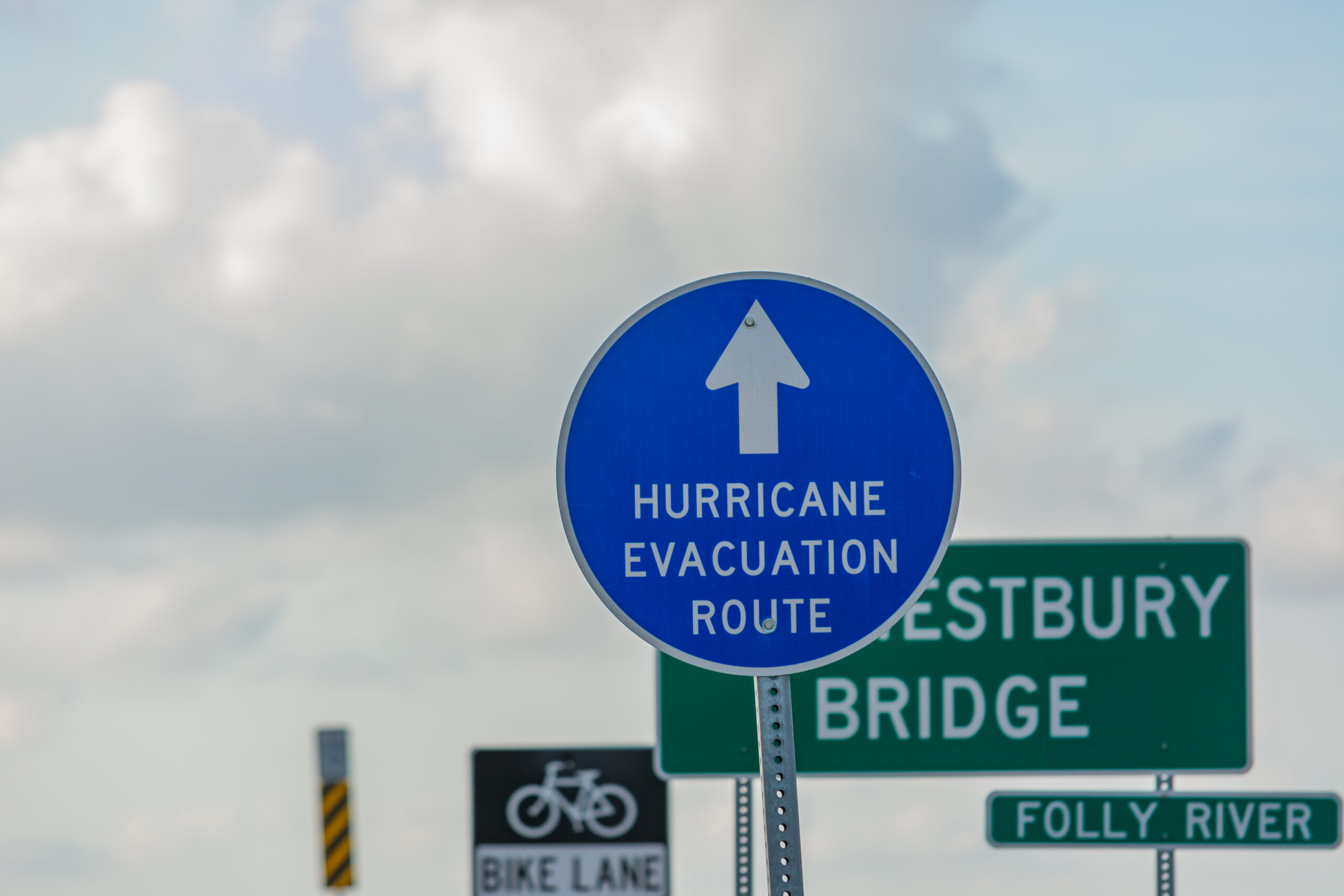 Blue sign with an arrow pointing up and text "HURRICANE EVACUATION ROUTE"